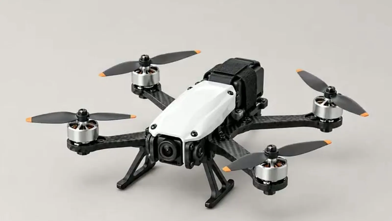 A fully assembled drone with a white body and black arms on a light grey studio backdrop
